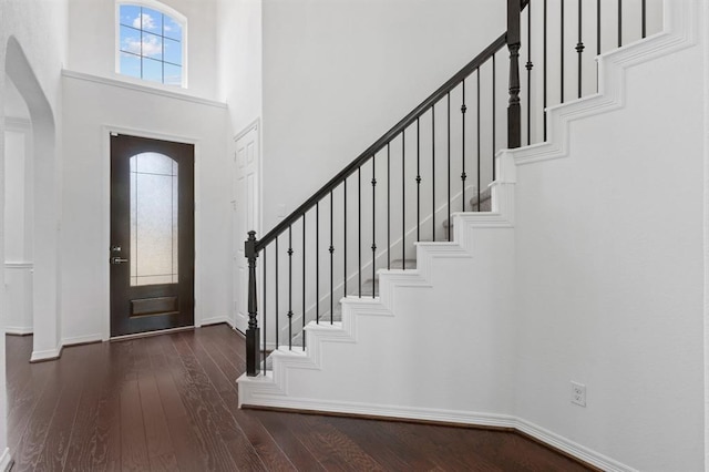 entrance foyer with a towering ceiling and dark hardwood / wood-style floors