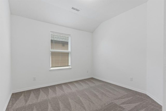 empty room featuring lofted ceiling and light colored carpet