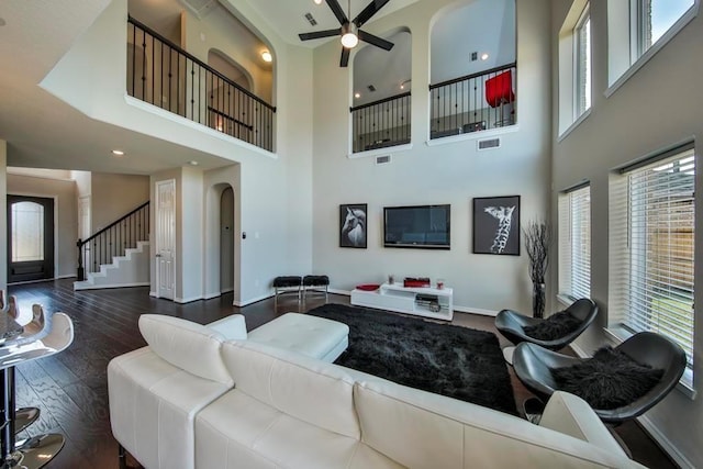 living room featuring ceiling fan and dark hardwood / wood-style flooring