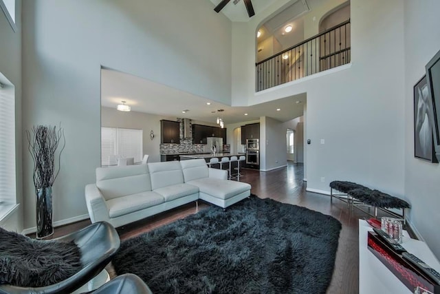 living room with ceiling fan and dark hardwood / wood-style flooring