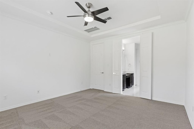 unfurnished room with light carpet, a tray ceiling, ornamental molding, and ceiling fan