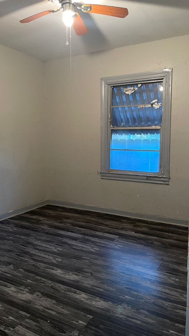 empty room with ceiling fan and dark hardwood / wood-style flooring