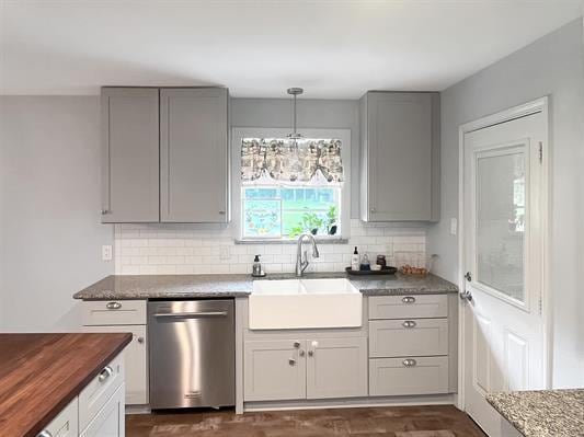 kitchen featuring decorative backsplash, sink, pendant lighting, and stainless steel dishwasher