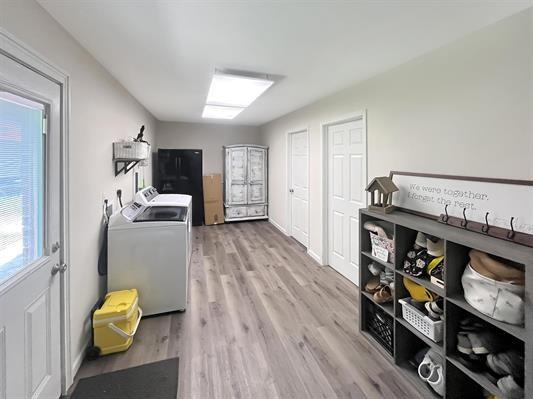 laundry area with light hardwood / wood-style floors and washer and clothes dryer