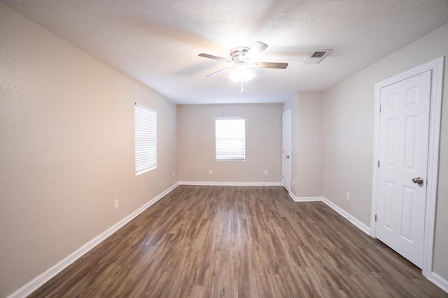 spare room with dark hardwood / wood-style floors, a textured ceiling, and ceiling fan