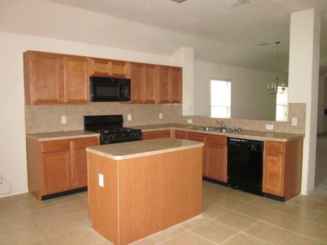 kitchen with kitchen peninsula, sink, decorative light fixtures, a kitchen island, and black appliances