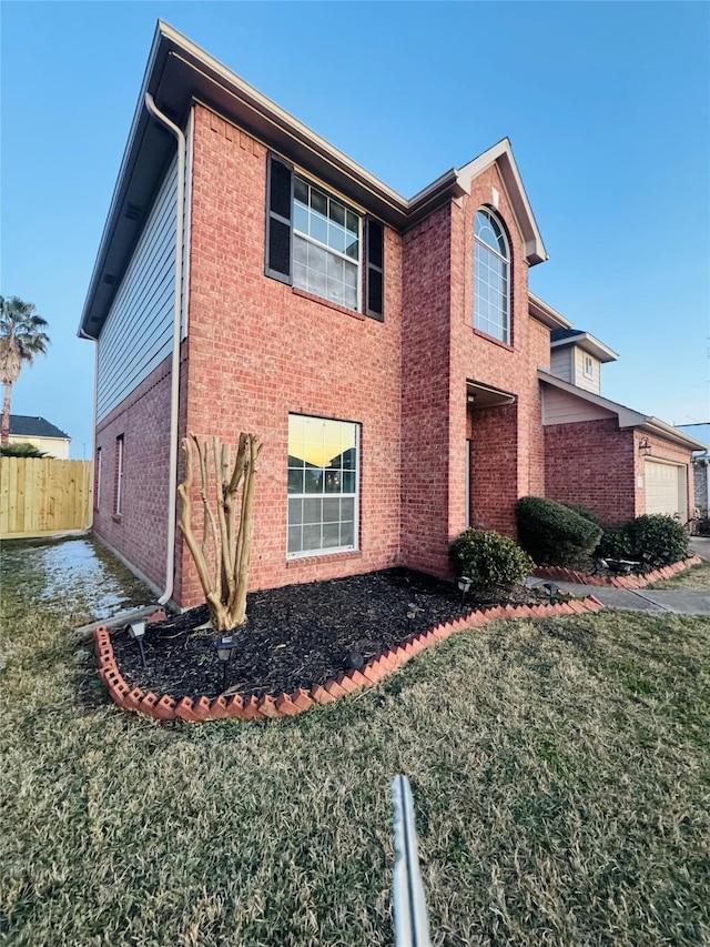 view of side of property with a garage and a lawn