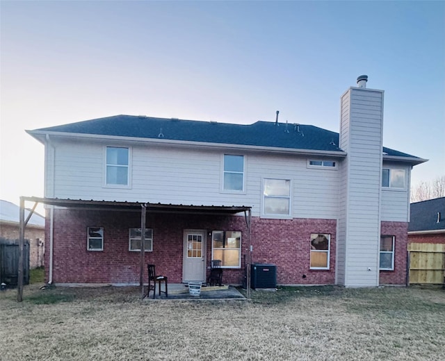 back of property featuring central AC, a lawn, and a patio