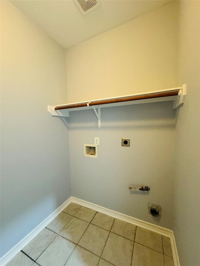 washroom with hookup for a washing machine, hookup for an electric dryer, and light tile patterned floors