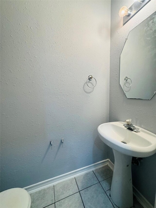 bathroom with toilet and tile patterned floors