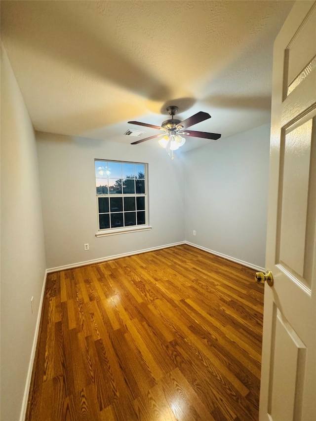 empty room featuring ceiling fan and hardwood / wood-style floors