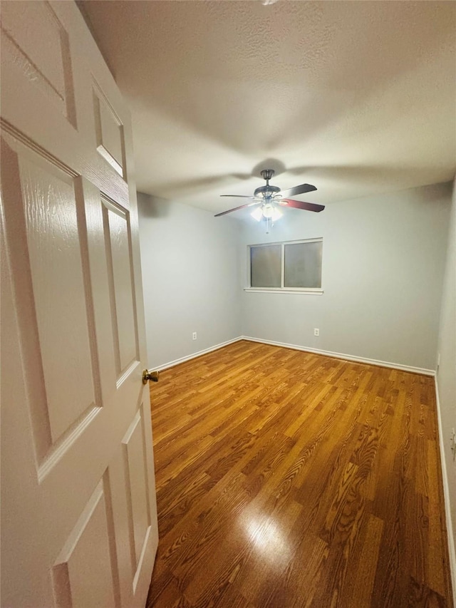 empty room with hardwood / wood-style flooring and ceiling fan