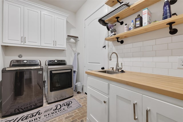 washroom with cabinets, sink, and independent washer and dryer