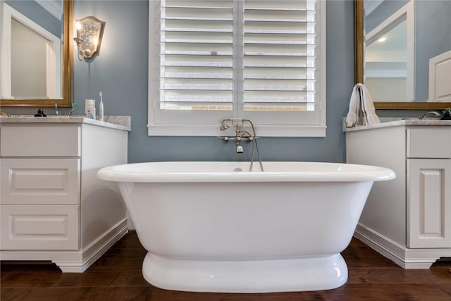 bathroom with vanity, hardwood / wood-style flooring, and a tub