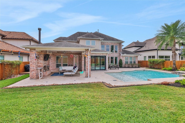 back of property with a fenced in pool, a yard, a patio, and an outdoor living space with a fireplace