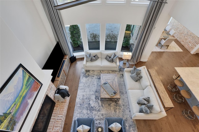 living room with hardwood / wood-style flooring and brick wall