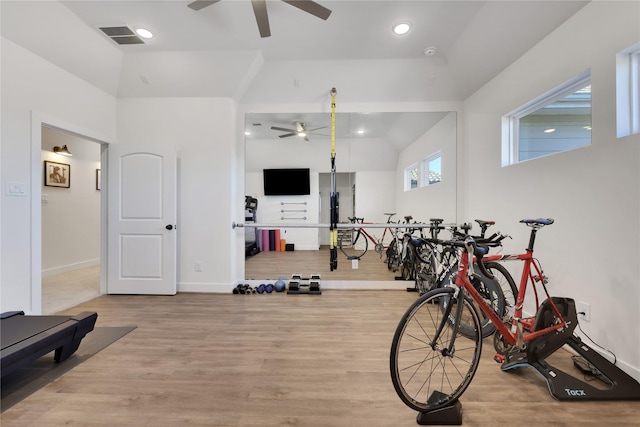 exercise room featuring ceiling fan, lofted ceiling, and light wood-type flooring