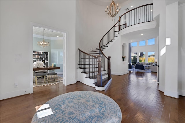 foyer featuring a notable chandelier, crown molding, and a high ceiling