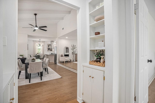 dining space featuring built in features, ceiling fan, hardwood / wood-style floors, and lofted ceiling with beams