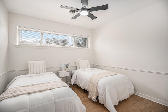 bedroom with hardwood / wood-style flooring, multiple windows, and ceiling fan