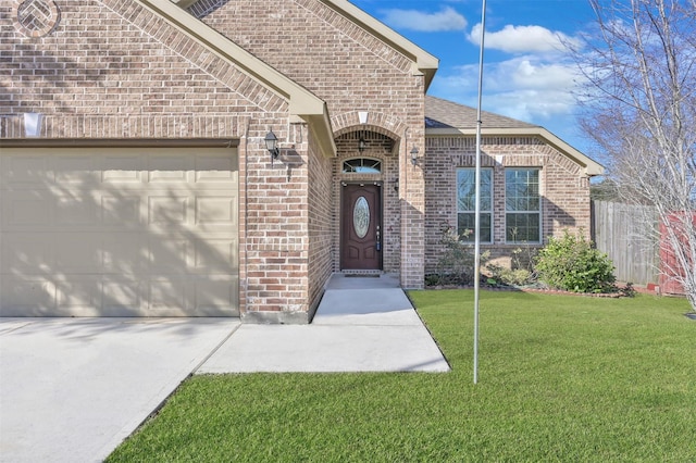 entrance to property with a garage and a lawn