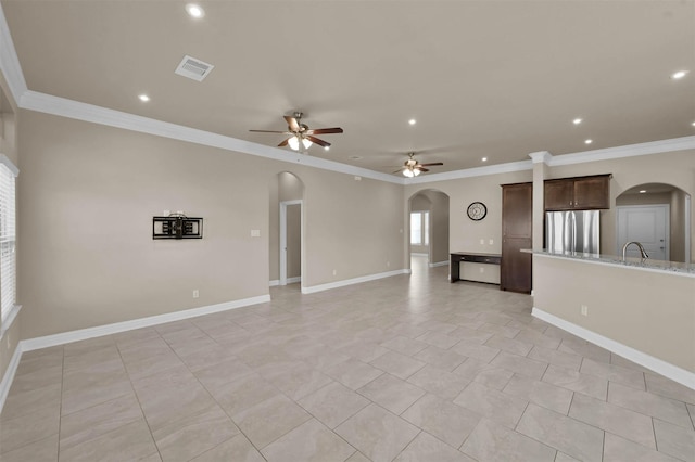 unfurnished living room with crown molding, ceiling fan, sink, and light tile patterned floors