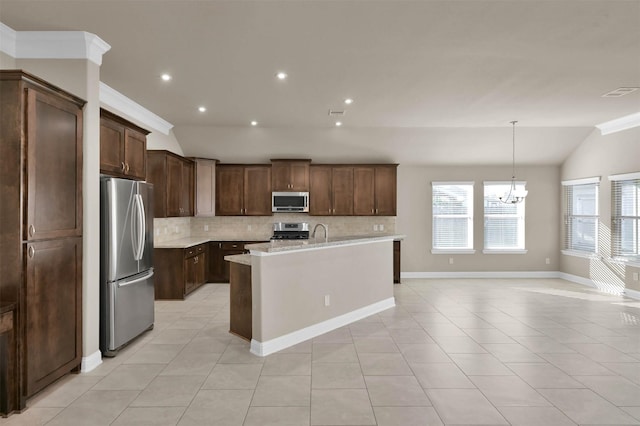 kitchen with lofted ceiling, hanging light fixtures, stainless steel appliances, dark brown cabinetry, and an island with sink