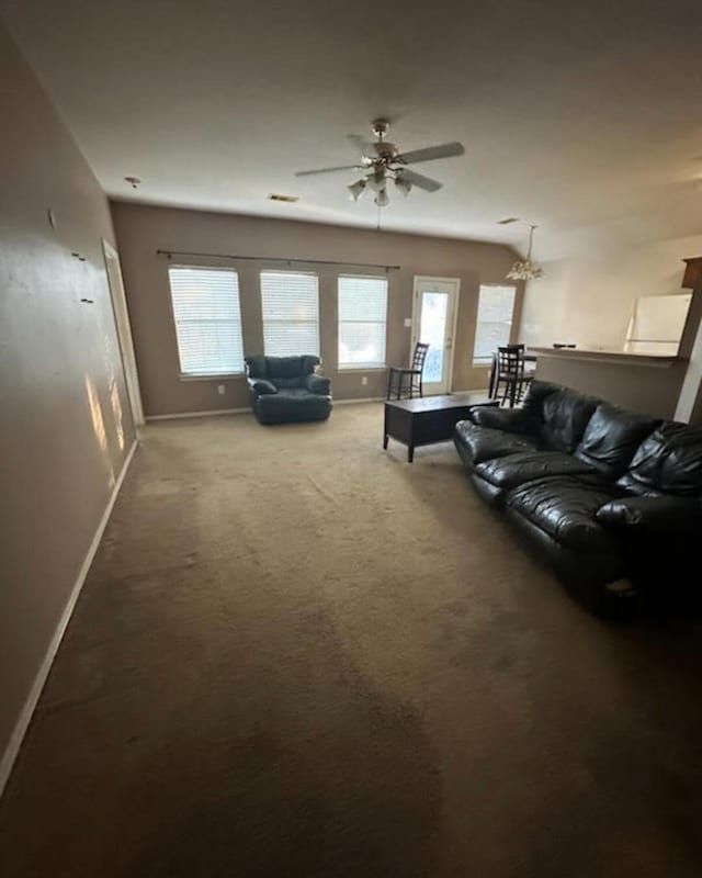 living room featuring carpet floors, ceiling fan, and a healthy amount of sunlight