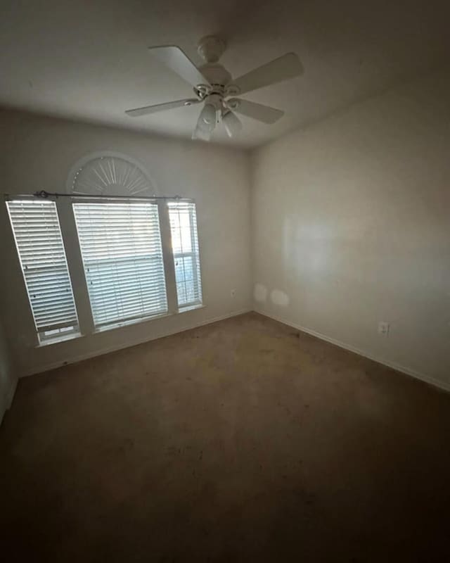 carpeted spare room featuring ceiling fan