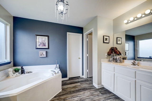 bathroom with vanity, a washtub, a chandelier, and wood-type flooring