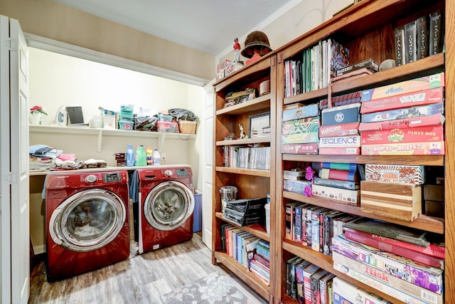 clothes washing area with washing machine and dryer and light hardwood / wood-style flooring