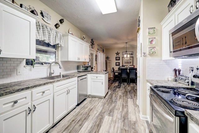 kitchen with sink, white cabinetry, and appliances with stainless steel finishes