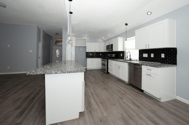 kitchen with white cabinetry, hanging light fixtures, sink, a kitchen island, and stainless steel appliances