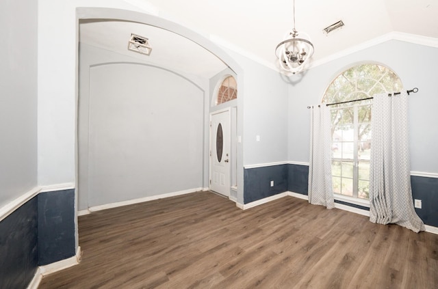 interior space featuring dark wood-type flooring, lofted ceiling, crown molding, and an inviting chandelier