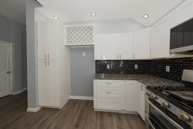 kitchen with tasteful backsplash, white cabinetry, dark hardwood / wood-style floors, dark stone countertops, and double oven range