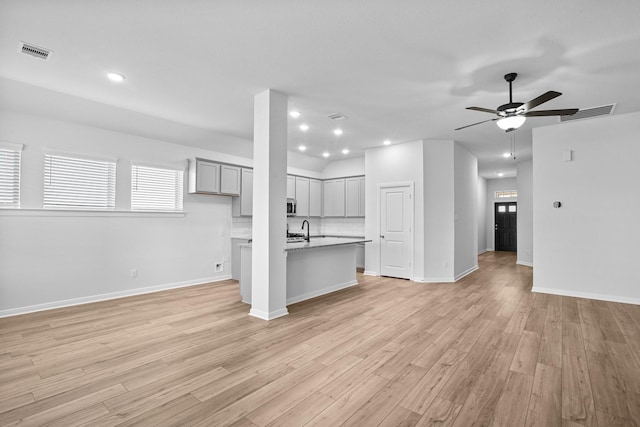 unfurnished living room featuring ceiling fan and light wood-type flooring