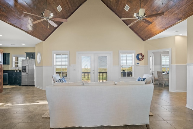 unfurnished living room featuring high vaulted ceiling, a healthy amount of sunlight, and wooden ceiling