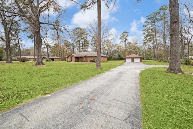 view of front of house featuring a garage, a front yard, and an outdoor structure