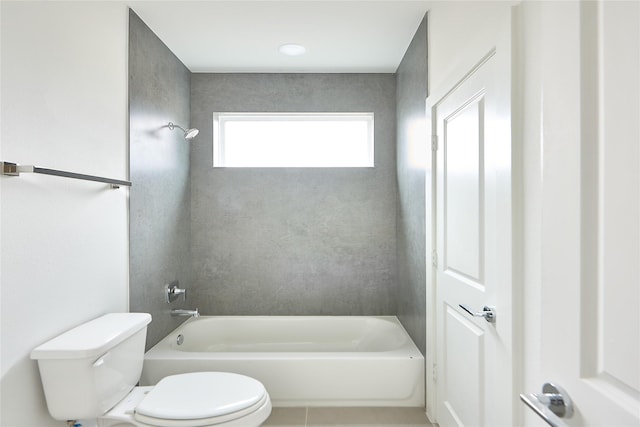 bathroom featuring tiled shower / bath, toilet, and tile patterned flooring