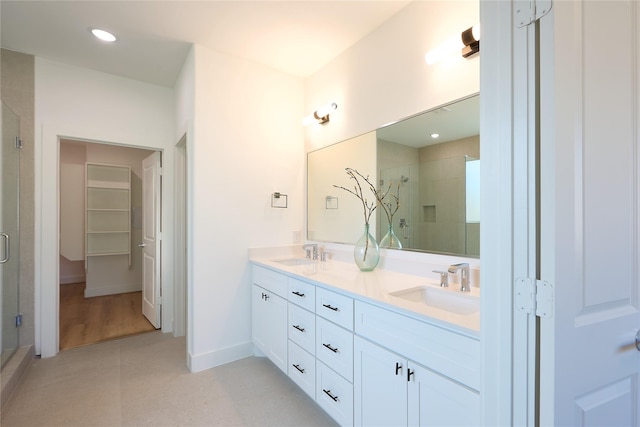 bathroom featuring vanity and a shower with door