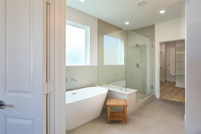 bathroom featuring shower with separate bathtub