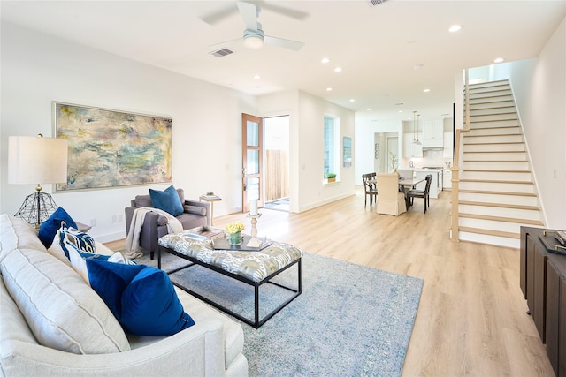 living room with ceiling fan and light wood-type flooring