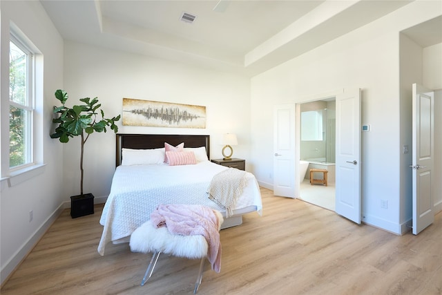 bedroom with a raised ceiling and light hardwood / wood-style flooring