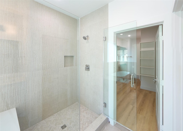 bathroom with hardwood / wood-style floors and tiled shower