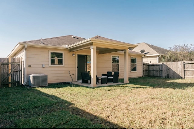 rear view of house with a patio, central air condition unit, and a yard