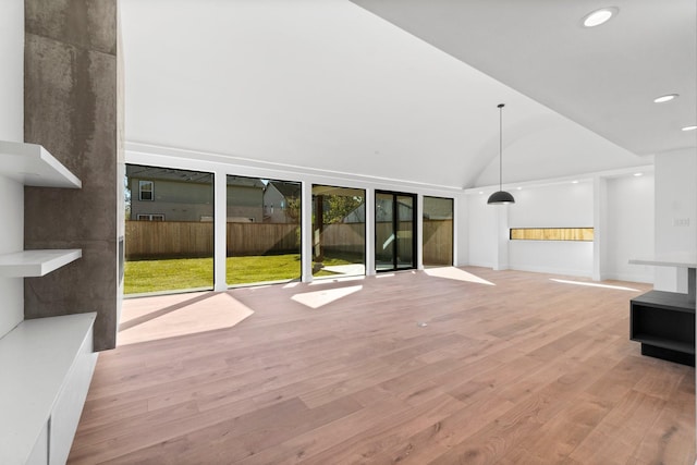 unfurnished living room featuring lofted ceiling and light hardwood / wood-style flooring