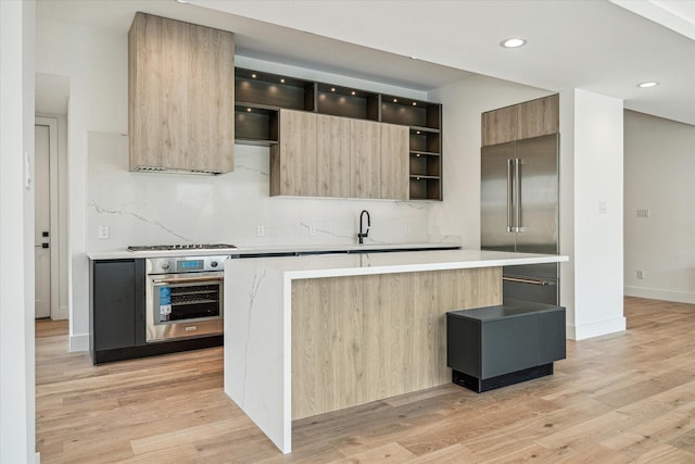 kitchen with a kitchen island, appliances with stainless steel finishes, and light hardwood / wood-style flooring