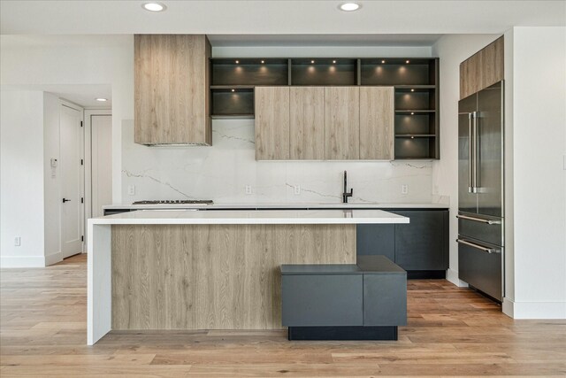 kitchen with a kitchen island, high quality fridge, sink, and decorative backsplash