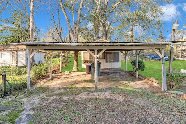 view of vehicle parking with a carport and a lawn