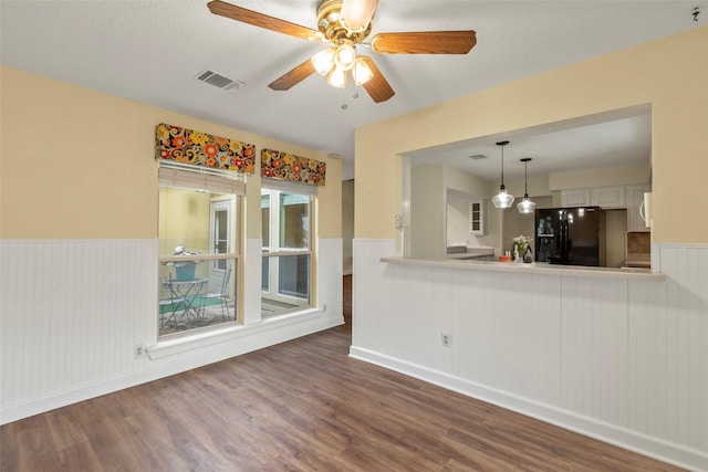 unfurnished living room with ceiling fan and dark wood-type flooring